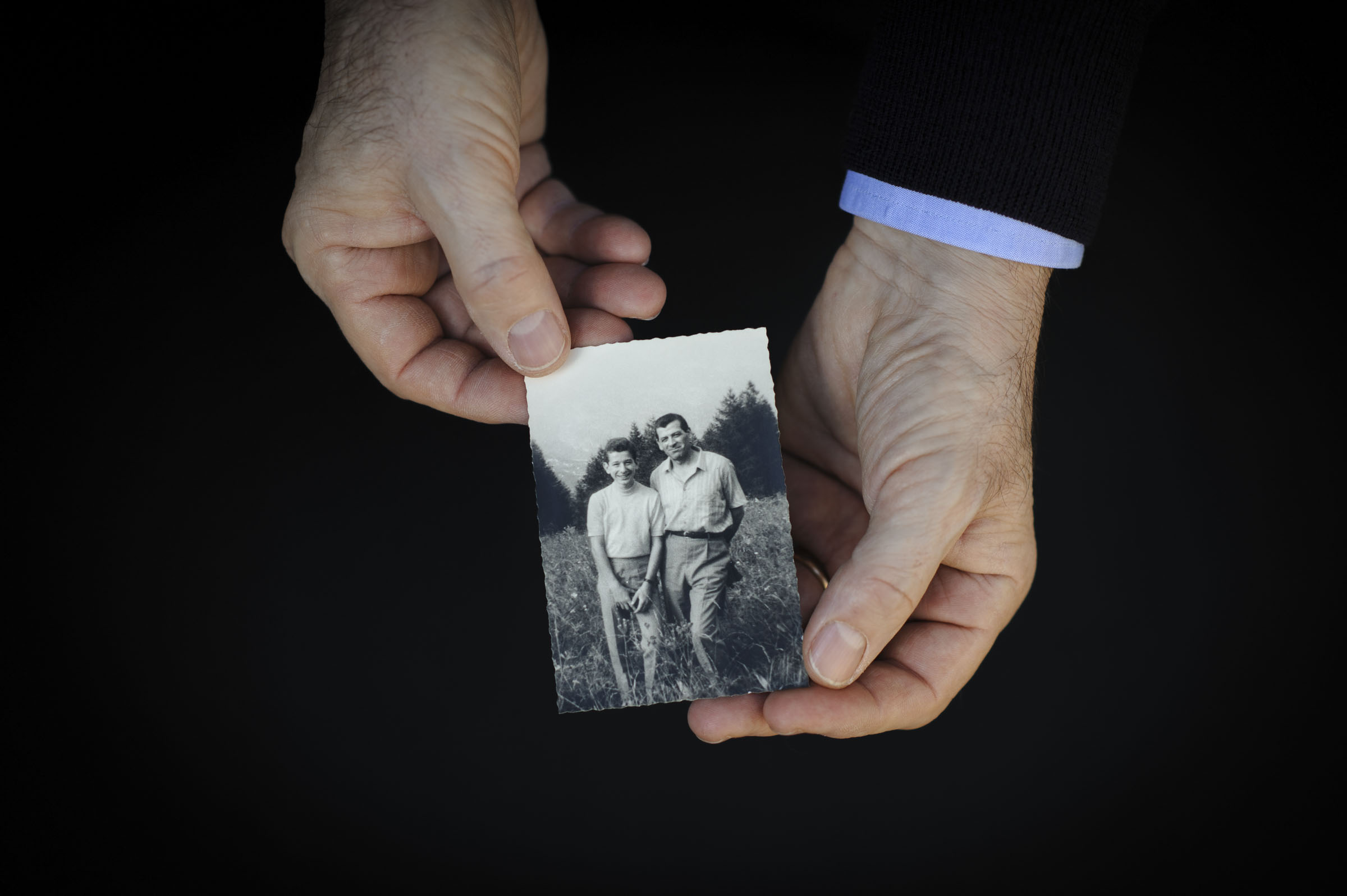 Zwei Hände halten ein Foto von Vater und Sohn.
