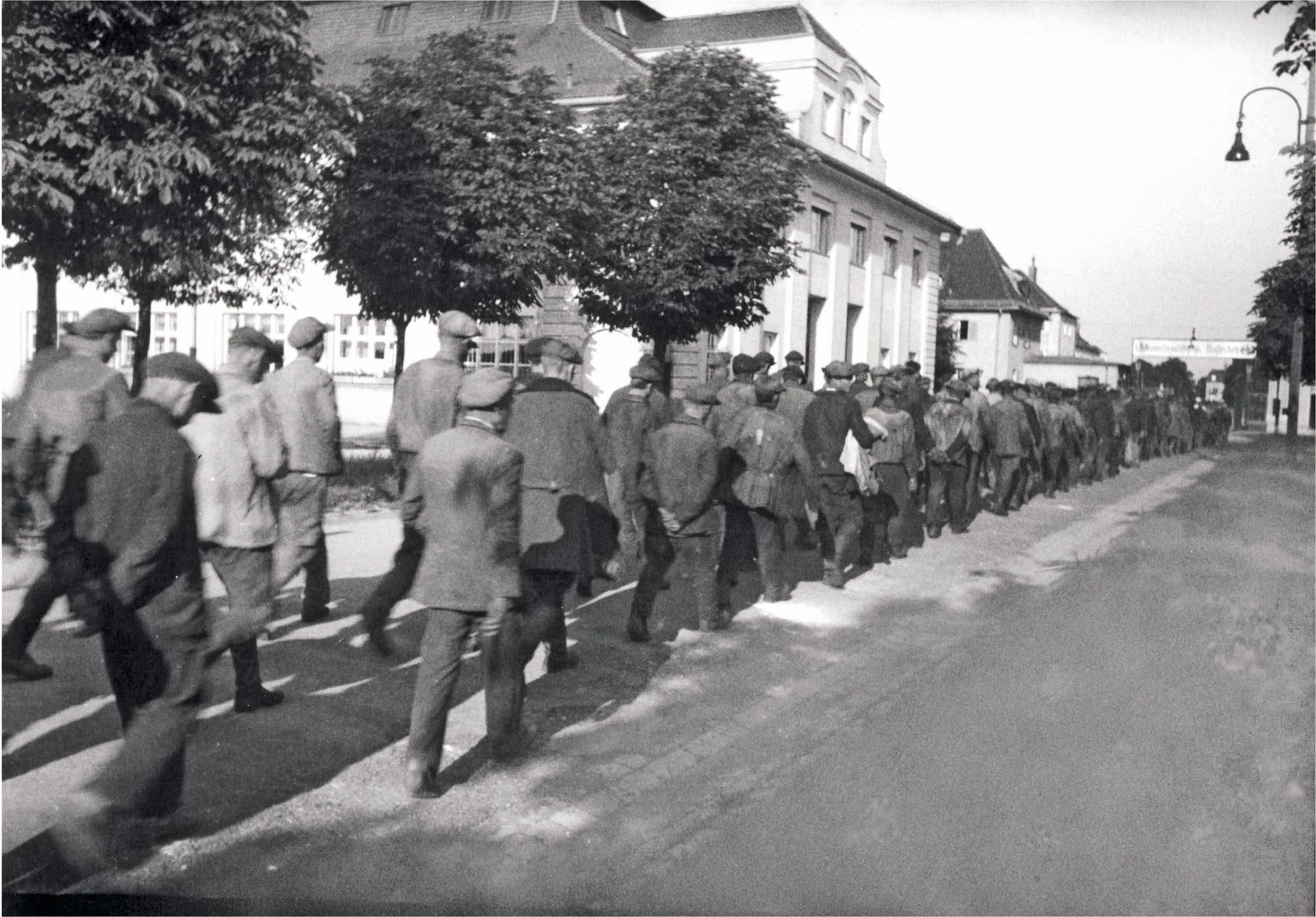Eine Gruppe von Zwangsarbeitern auf dem Weg zur Arbeit