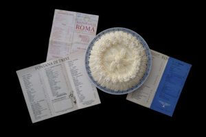 Un dolce al cucchiaio in una coppa, posta sopra un menù