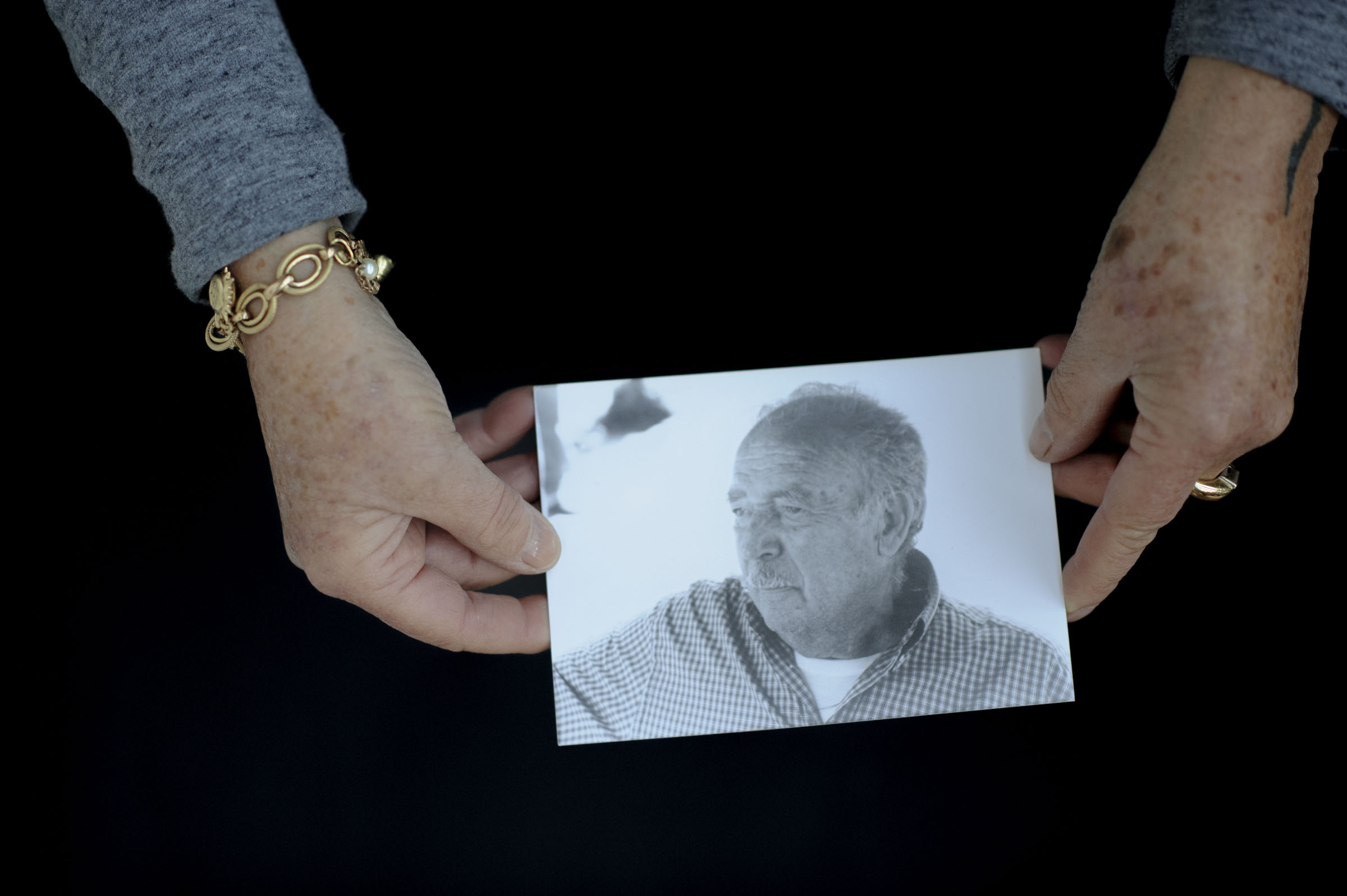 Due mani sorreggono un ritratto fotografico.